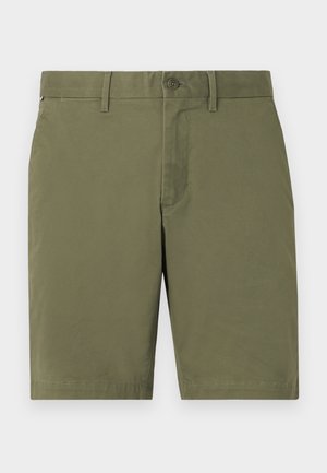 Shorts vert olive en tissu léger, dotés d'une fermeture à un bouton, de passants de ceinture et d'un ourlet propre sans motifs ni accents visibles.