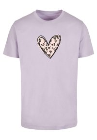 Camiseta de algodón lila con un diseño de corazón en rosa pálido, con un contorno negro y una textura de estampado de leopardo dentro de la forma del corazón.