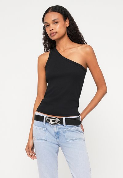 Top noir à une épaule, design ajusté, tissu texturé. Assorti avec un jean en denim bleu clair et une ceinture noire dotée d'une boucle ovale en argent.