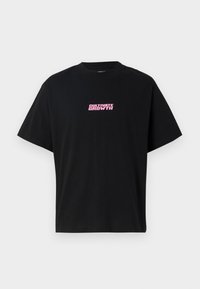Black cotton t-shirt with short sleeves. Features a pink graphic text "CULTIVATE GROWTH" centered on the front. Simple design, relaxed fit.