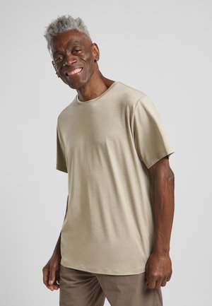 Lichtbeige, korte mouwen t-shirt met een ronde halslijn, gladde textuur en een relaxte pasvorm. Draag door een glimlachend individu.
