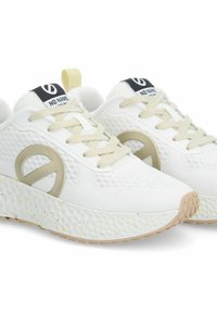 Sneaker bianche con tomaia in rete testurizzata, lacci beige e un grande logo beige sul lato. Leggeri puntini sulla suola in gomma.