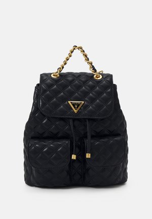 Sac à dos en cuir matelassé noir avec poignée chaîne dorée, deux poches avant, fermeture par cordon et logo triangulaire Guess sur le rabat.