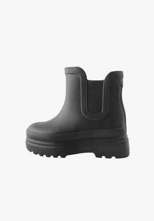 Cizmă de gleznă din cauciuc negru, cu un finisaj texturat, panouri laterale elastice și o talpă masivă. Design elegant cu detalii minime.
