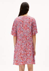 Blumenkleid in Rot, mit kurzen Ärmeln, rundem Halsausschnitt und lockerer Passform. Der Stoff hat eine leichte, gemusterte Textur.