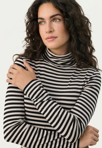 Black and beige striped turtleneck sweater with long sleeves, featuring a fitted design and soft fabric texture.