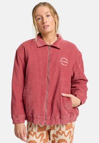 Giacca in corduroy color rosa con zip frontale, polsini elasticizzati e tasche laterali; presenta un ricamo con logo rotondo sul lato sinistro del petto.