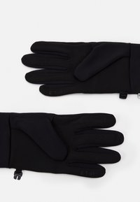 Gants noirs en tissu extensible, dotés d'une prise texturée sur les paumes et d'une sangle réglable. La marque ETIP est visible sur les bouts des doigts.