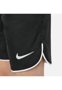 Shorts de sport noirs en tissu lisse, arborant un logo Nike blanc, des bordures blanches contrastantes et un ourlet incurvé pour plus de mobilité.