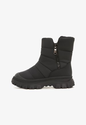 Bota aislante negra con un diseño acolchado, cremallera lateral, suela de goma y una suela gruesa y texturizada para tracción.