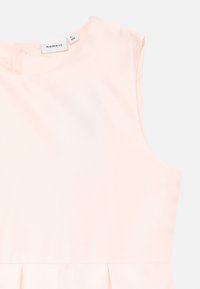 Lys rosa ermeløs kjole med en glatt tekstur, rund halslinning og rynket skjørtdetalj i kanten. Lappen viser merket "name it" og størrelse 12.