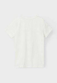 Kortærmet T-shirt med rund hals i lys cremefarve, lavet af blødt bomuldsstof. Ensfarvet ryg uden synlig branding eller mønstre.