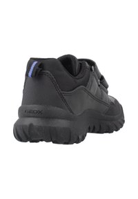 Zapatilla Geox negra con suela de goma texturizada, collar acolchado, parte superior de malla y sintética, y tirador azul a rayas en el talón.