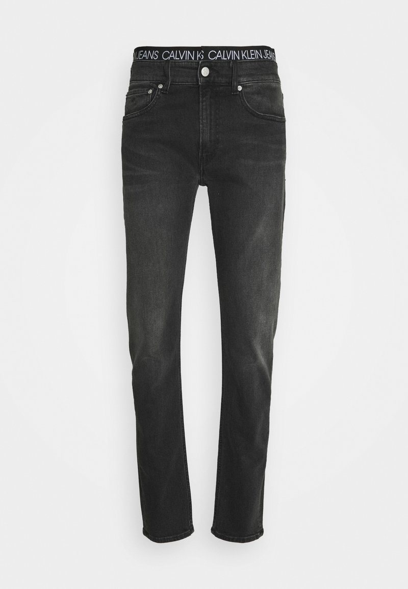 Černé džíny s rovnými nohavicemi, vyrobené z denimu. Mají pas s logem Calvin Klein a klasický design s pěti kapsami.