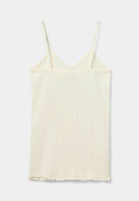 Ujjatlan topp világos krém színben, bordás textúrával és finom függőleges csíkkal, alján rojtos szegéssel.