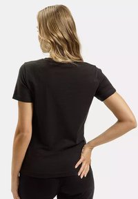 Czarna koszulka z krótkim rękawem, wykonana z bawełny, z klasycznym okrągłym dekoltem i gładką strukturą, bez widocznych wzorów czy akcentów.