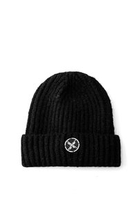 Gorro de punto negro con textura acanalada, puño doblado y un parche bordado redondo con un diseño en blanco.