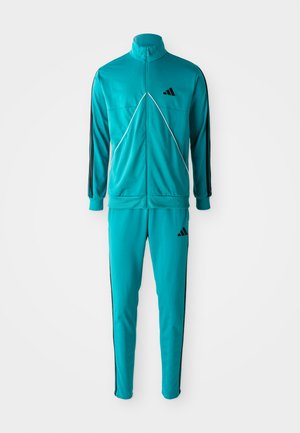 Teal full-zip trainingsjack en bijpassende trainingsbroek met zwarte strepen en kleine zwarte logo's op de borst en dij.