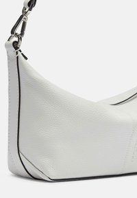 Sacoche en cuir blanc avec une surface texturée, une forme courbée et un passepoil noir le long des bords. Présente une attache à clip en argent.