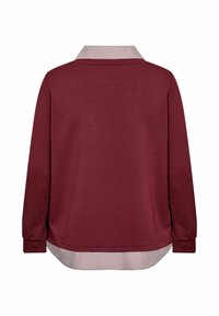 Camiseta de manga larga burdeos con cuello y dobladillo a rayas. Presenta una tela suave, un corte relajado y un dobladillo trasero curvado para mayor longitud.