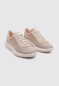 Zapatillas de malla ligeras en tonos beige y gris con cordones elásticos, cuello acolchado y suela de goma lisa. Diseño transpirable para mayor comodidad.