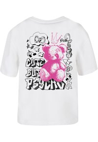 T-shirt blanc avec une illustration d'ours rose et un texte de style graffiti indiquant "MIGNON MAIS PSYCHO" avec des accents noirs et des gribouillis.