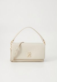 Beige Lederhandtasche mit glatter Oberfläche, goldfarbenen Beschlägen, abnehmbarem Schultergurt und einem auffälligen Logo auf der Vorderseite.