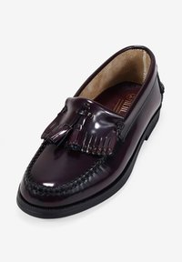 Mocasines de cuero burdeos con borlas, con un diseño cosido y suela de goma negra. Acabado suave con un forro interior.