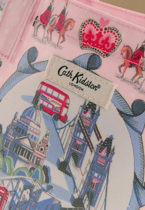 Látka s tématem Londýna s červeným dvoupatrovým autobusem, Tower Bridge, královskými strážemi na koních a červenou korunou nad štítkem Cath Kidston.