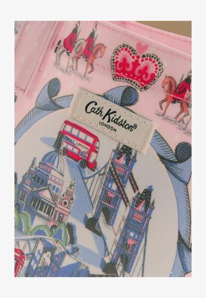 London témájú szövet piros emeletes busszal, Tower Bridge-csel, palotai lovas őrökkel és egy piros koronával a Cath Kidston címke felett.