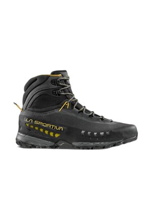 Scarpa da trekking La Sportiva alta nera e gialla con suola rinforzata, supporto alla caviglia e chiusura con lacci su sfondo bianco.