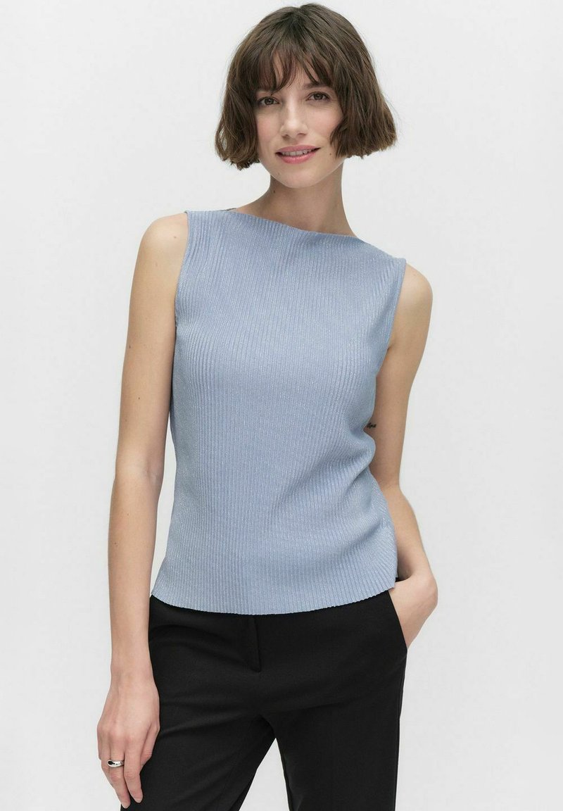 Vaaleansininen hihaton paita, jossa on ribbikuvio ja tiukka leikkaus, sekä korkea kaula-aukko, yhdistettynä mustiin housuihin.