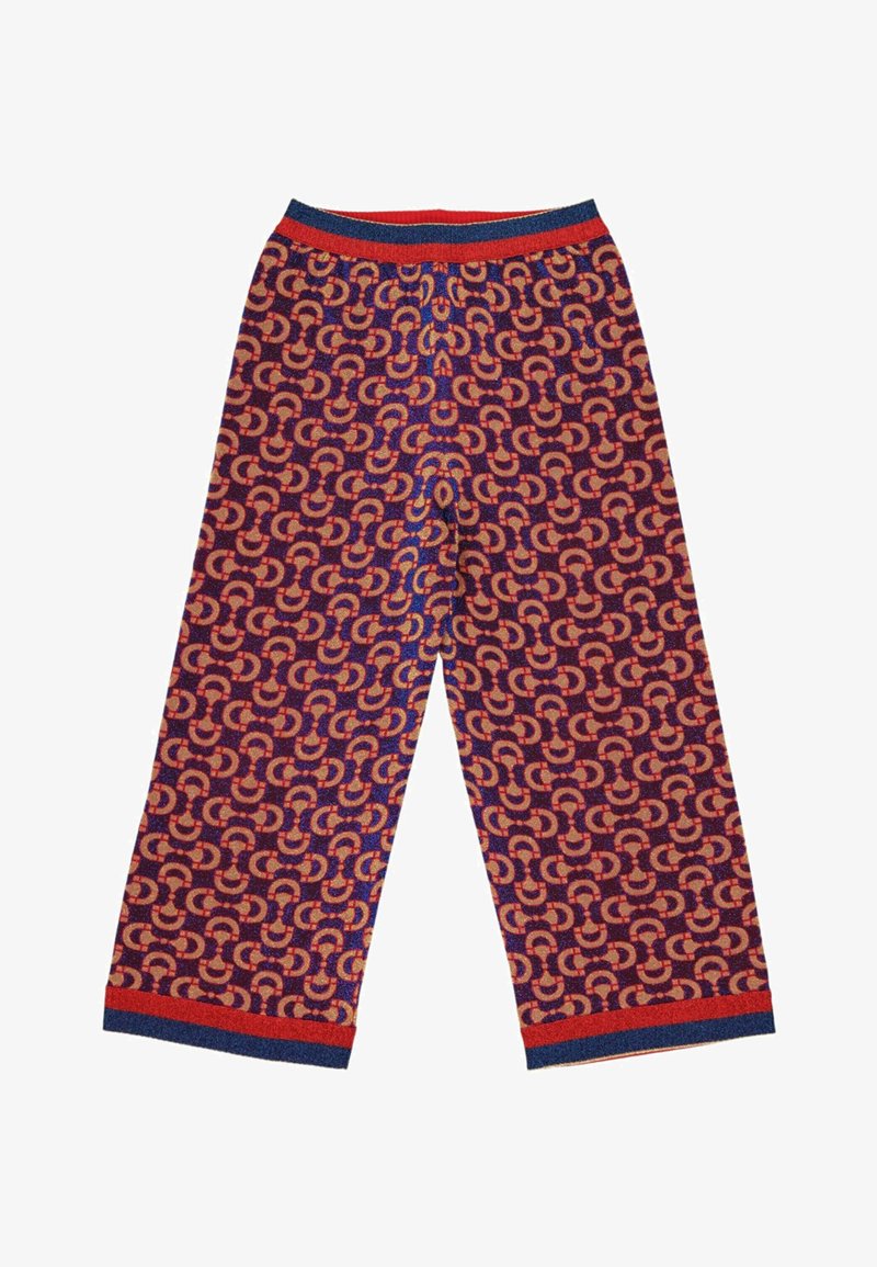 Pantalon à jambes larges avec un motif en fer à cheval rouge et bleu répétitif et une ceinture et des poignets rayés rouges et bleus sur fond blanc.