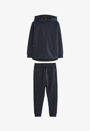 Marineblå hættetrøje med lynlås foran og lommer samt matchende joggingbukser med lynlåslommer og elastiske manchetter ved anklerne.