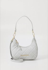 Mala de mão cinzenta acolchoada em pele, com uma silhueta curva, ferragens douradas e alça de ombro destacável. Apresenta o nome "Valentino" em dourado.