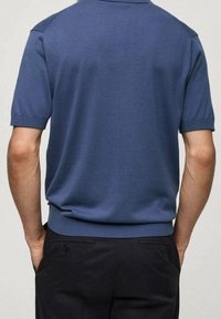 Short-sleeve polo shirt in blue cotton blend. Features a ribbed collar and hem, with a smooth texture and fitted design. Back view shown.