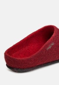 Red felt slipper with a rounded shape, soft texture, and a black rubber sole. Features a small logo on the side.