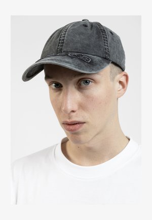 Boné de basebol preto em denim com detalhes costurados, aba curva e logótipo bordado na frente. Usado por um modelo com uma t-shirt branca.