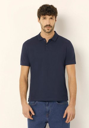 Polo bleu marine en coton lisse avec un col et une patte de boutonnage à trois boutons. Manches courtes et coupe droite.