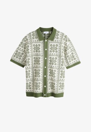 Camicia a maniche corte con bottoni, colletto e polsini verdi, con motivo floreale quadrato oliva e bianco su sfondo crema.