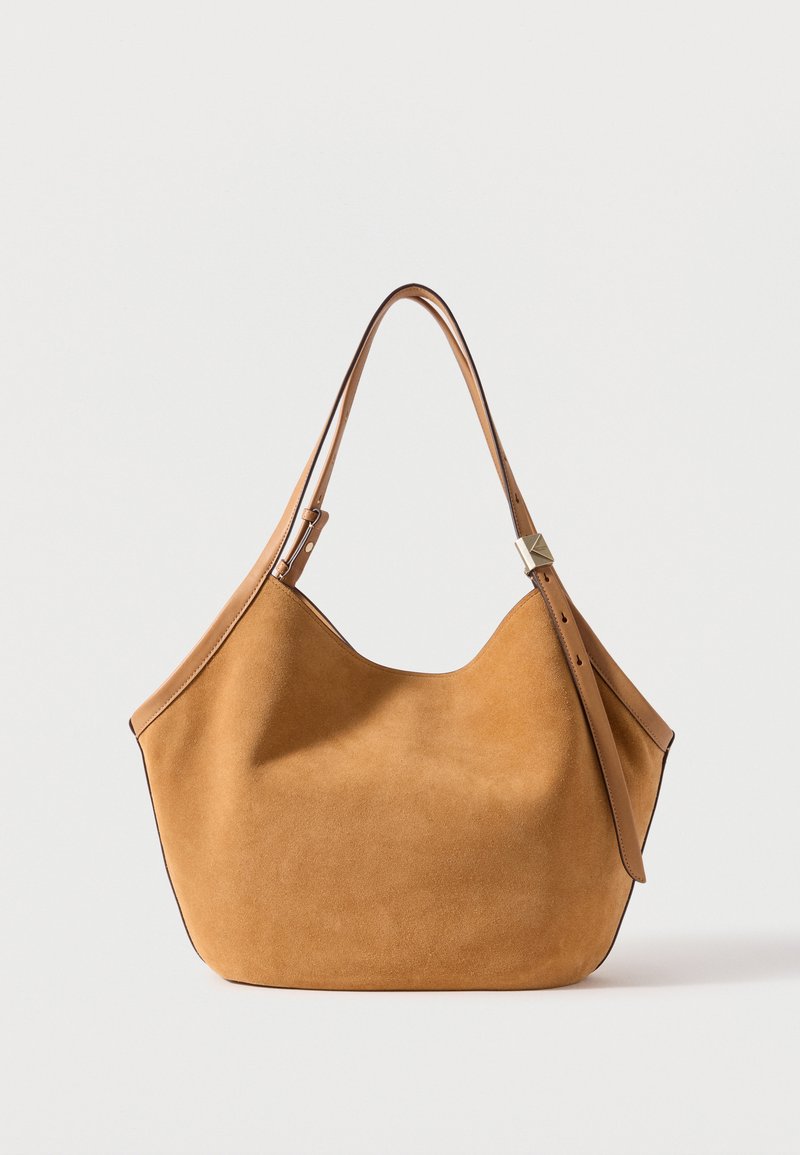 Ταμπά τσάντα ώμου από σουέντ με ρυθμιζόμενο δερμάτινο λουρί και ασημένια αγκράφα σε λευκό φόντο.