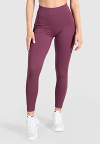 Burgundin korkea vyötärö leggingsit, valmistettu venyvästä kankaasta. Ominaisuuksia: sileä tekstuuri ja hienovaraiset saumat. Yhdistetty valkoisiin urheilukenkään.