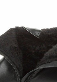 Chaqueta de cuero negra con cierre de cremallera y un forro suave y texturizado en negro. Los detalles notables incluyen un cuello liso y costuras.