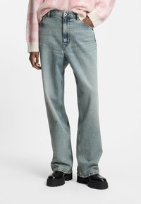 Jasnoniebieskie proste jeansy z denimu z wysokim stanem, charakteryzujące się klasycznym fasonem z pięcioma kieszeniami i delikatnym wyblaknięciem.