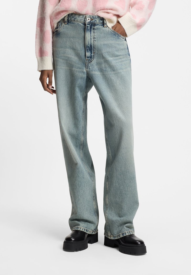 Jasnoniebieskie proste jeansy z denimu z wysokim stanem, charakteryzujące się klasycznym fasonem z pięcioma kieszeniami i delikatnym wyblaknięciem.