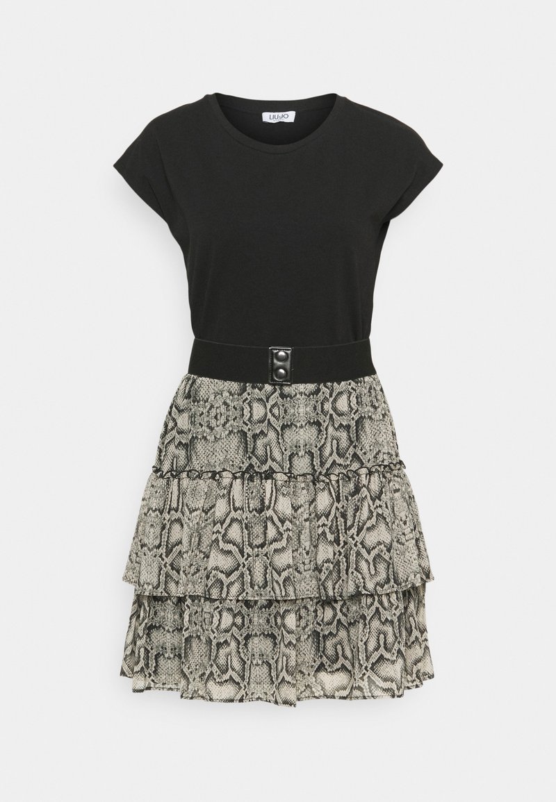 Schwarzes T-Shirt mit kurzen Ärmeln, kombiniert mit einem schichtenartigen Schlangenprint-Rock in Grautönen und Beige, der einen schwarzen Taillenbund mit Knöpfen hat.