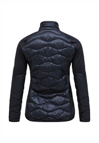 Gevulde zwarte jas met een gequilt patroon op de achterkant, met een hoge kraag en contrasterende stof op de mouwen en zijkanten.