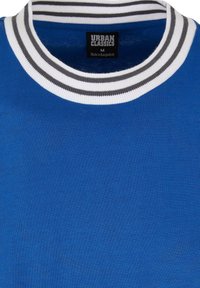 Kék póló bordázott gallérral, fehér és szürke csíkokkal. A címke szerint "URBAN CLASSICS", "M" méret, Bangladesben készült.