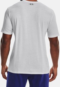 Short-sleeve white t-shirt shown from the back. Made of soft fabric with a rounded neckline and a small black logo at the collar.