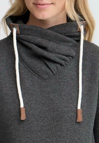 Felpa grigia heather con colletto a tunnel, caratterizzata da lacci bianchi e dettagli in pelle marrone. Stoffa morbida con una vestibilità comoda e una texture sottile.